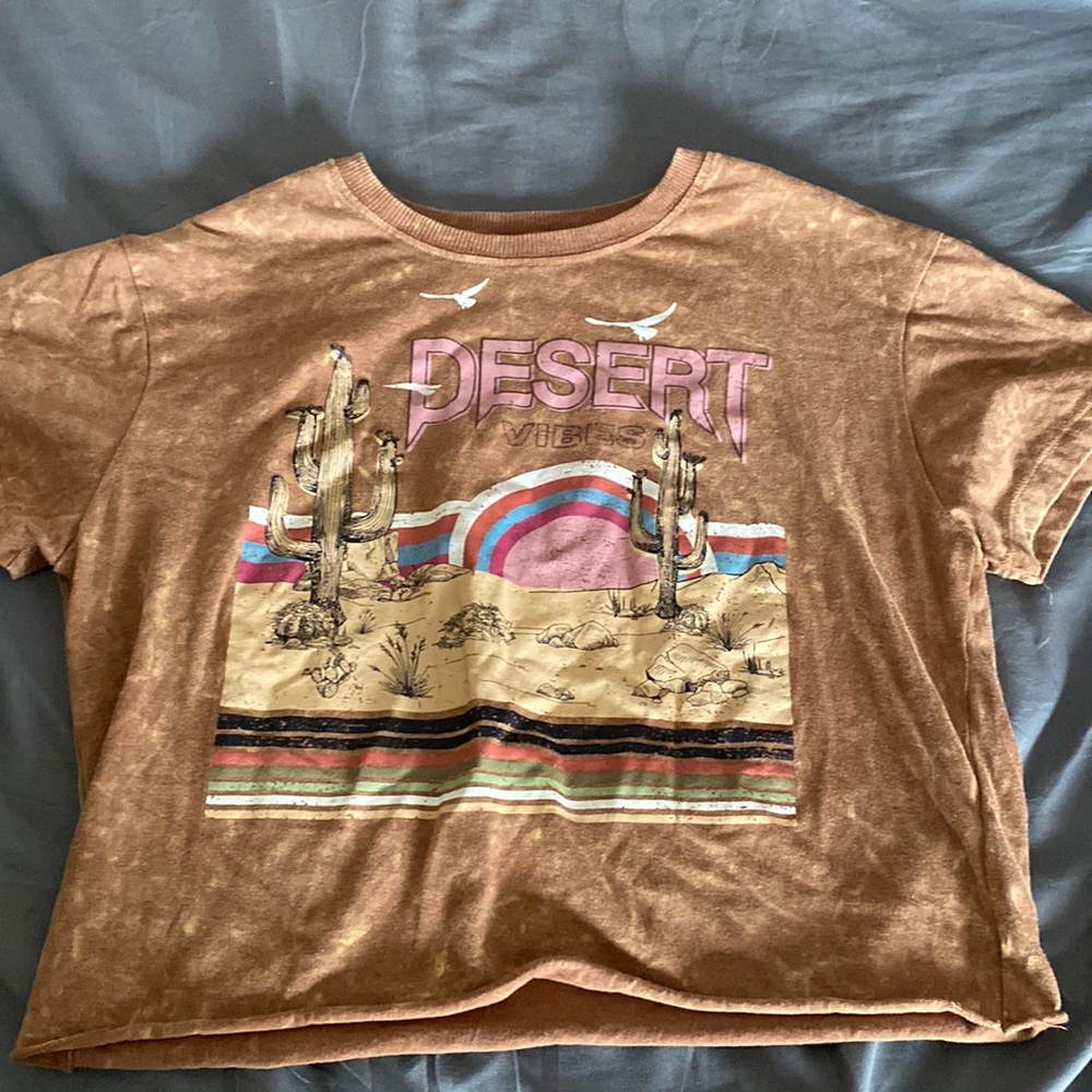 Size medium in kids brown and it says desert vibes with a desert picture
